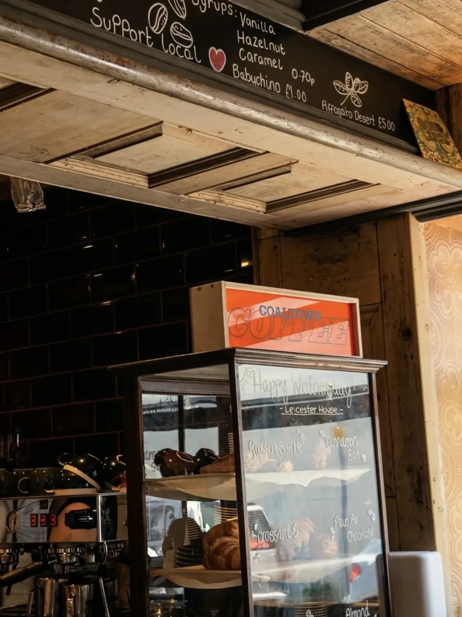 The coffee counter with chalkboard menu and pastry cabinet