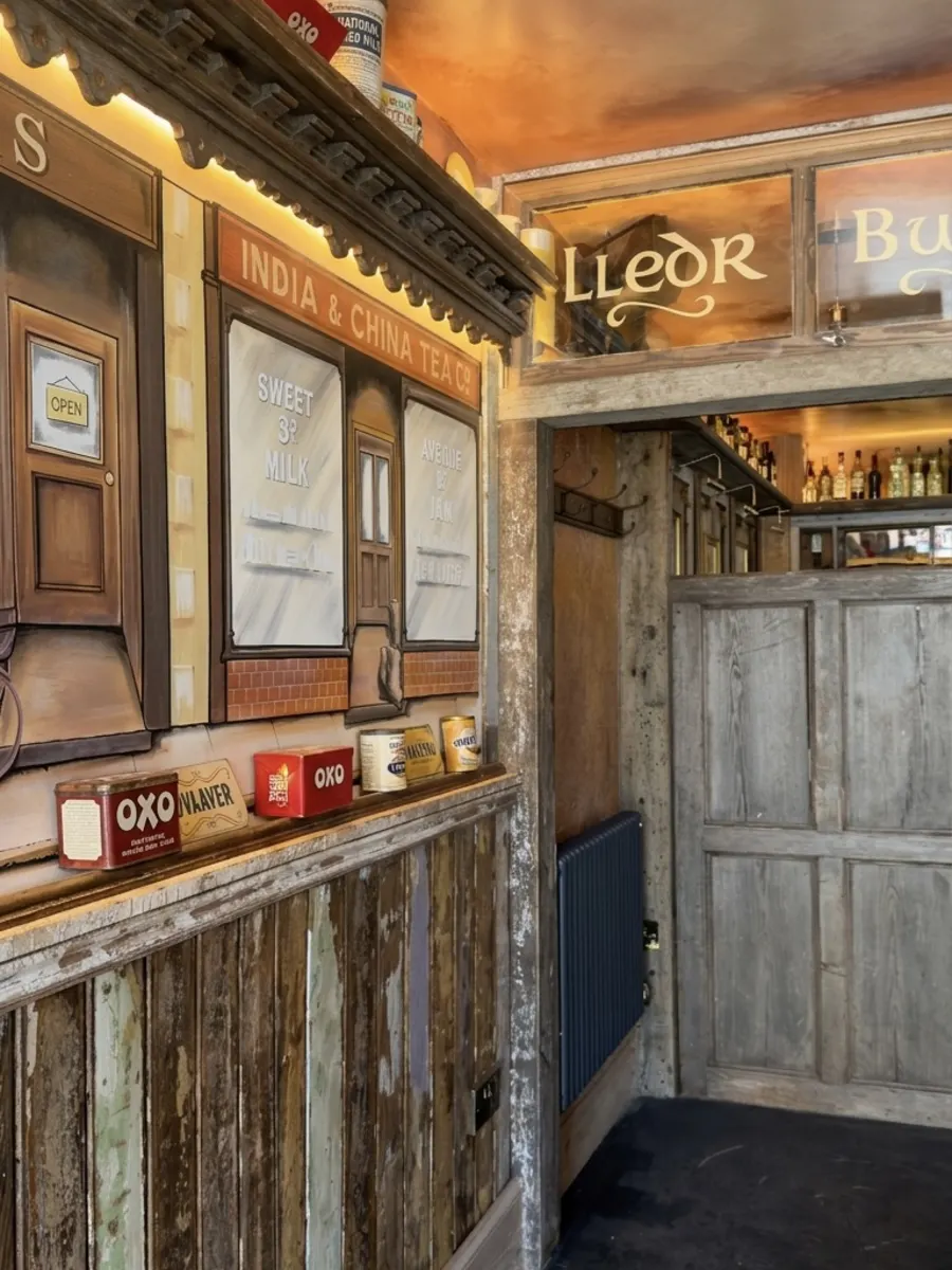 Hand-painted vintage shopfront mural along the café wall