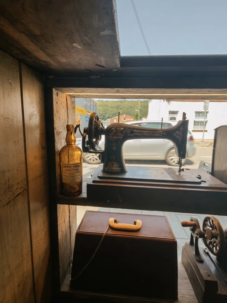 An antique Singer sewing machine in the window, the High Street beyond